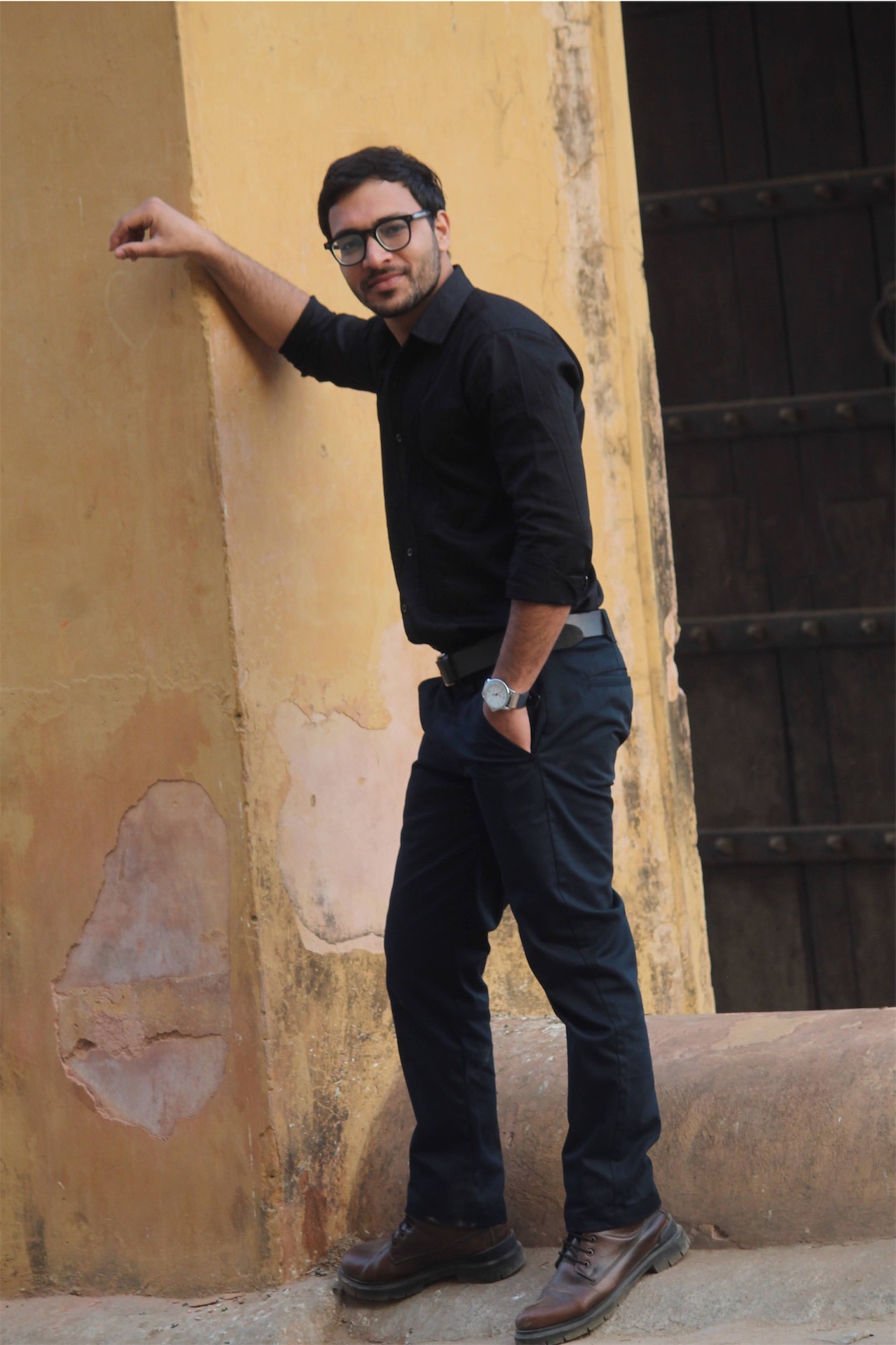 Man leaning against yellow wall